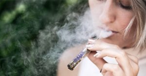 Žena fajčí marihuanu cez sklenený blunt