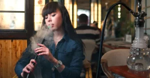 Mladá žena fajčí vodnú fajku